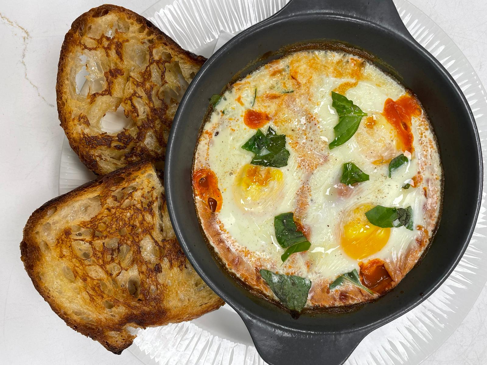 Baked eggs brunch dish served with sourdough toast