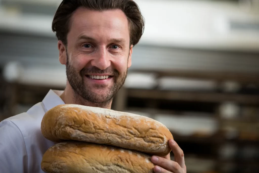 A baker carrying freshly baked loaves