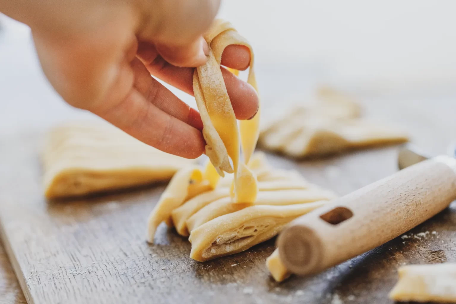 Fresh pasta being rolled by hand